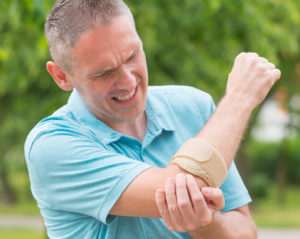 Man wearing elbow brace to reduce pain